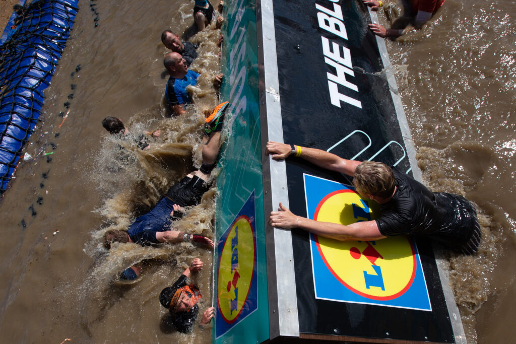 people on water obstacle with Lidl branding
