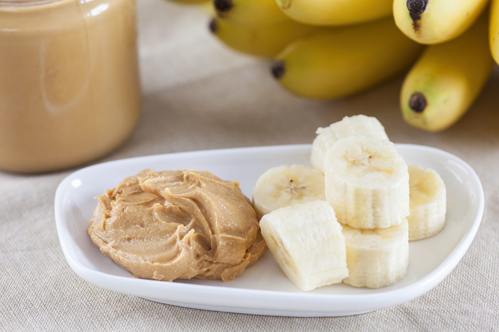 Banana slices and peanut putter on a plate