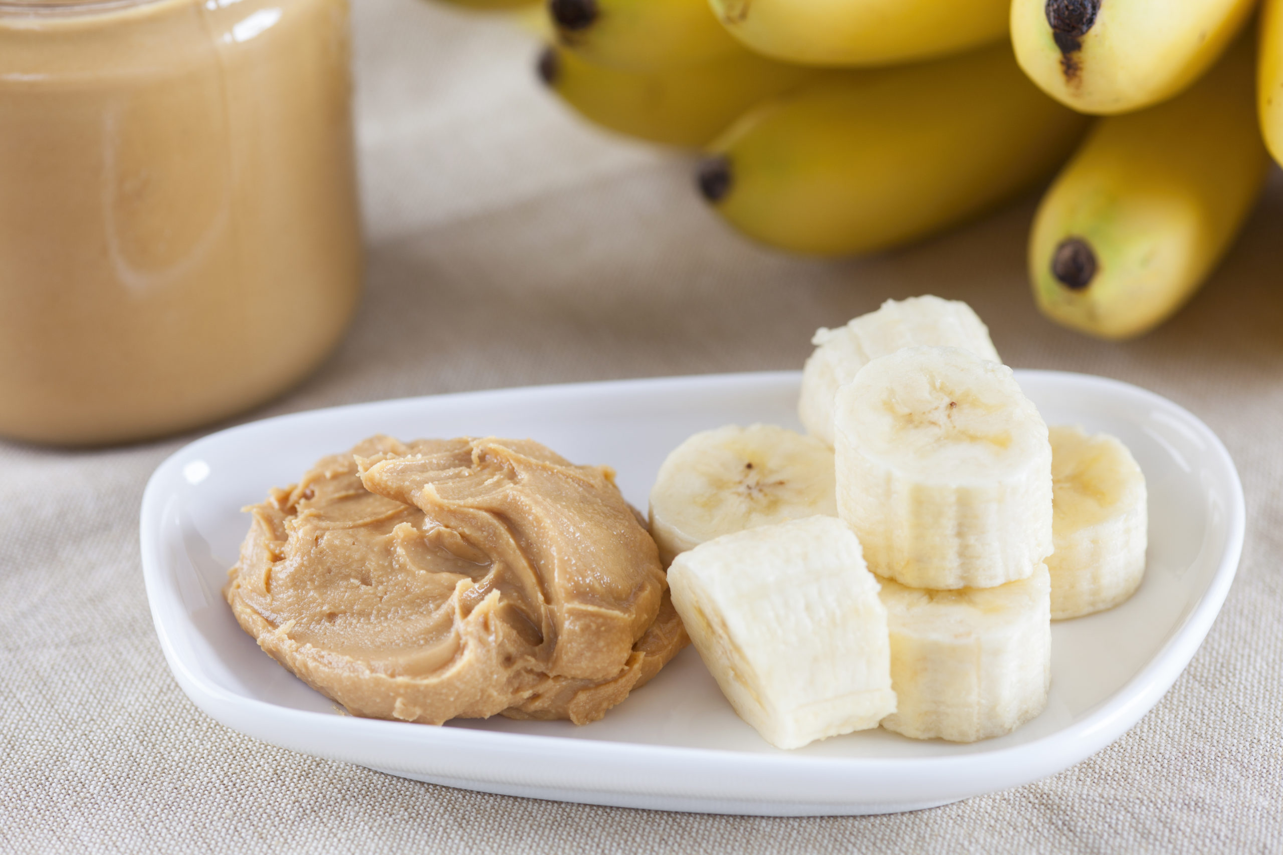 Banana slices and peanut putter on a plate