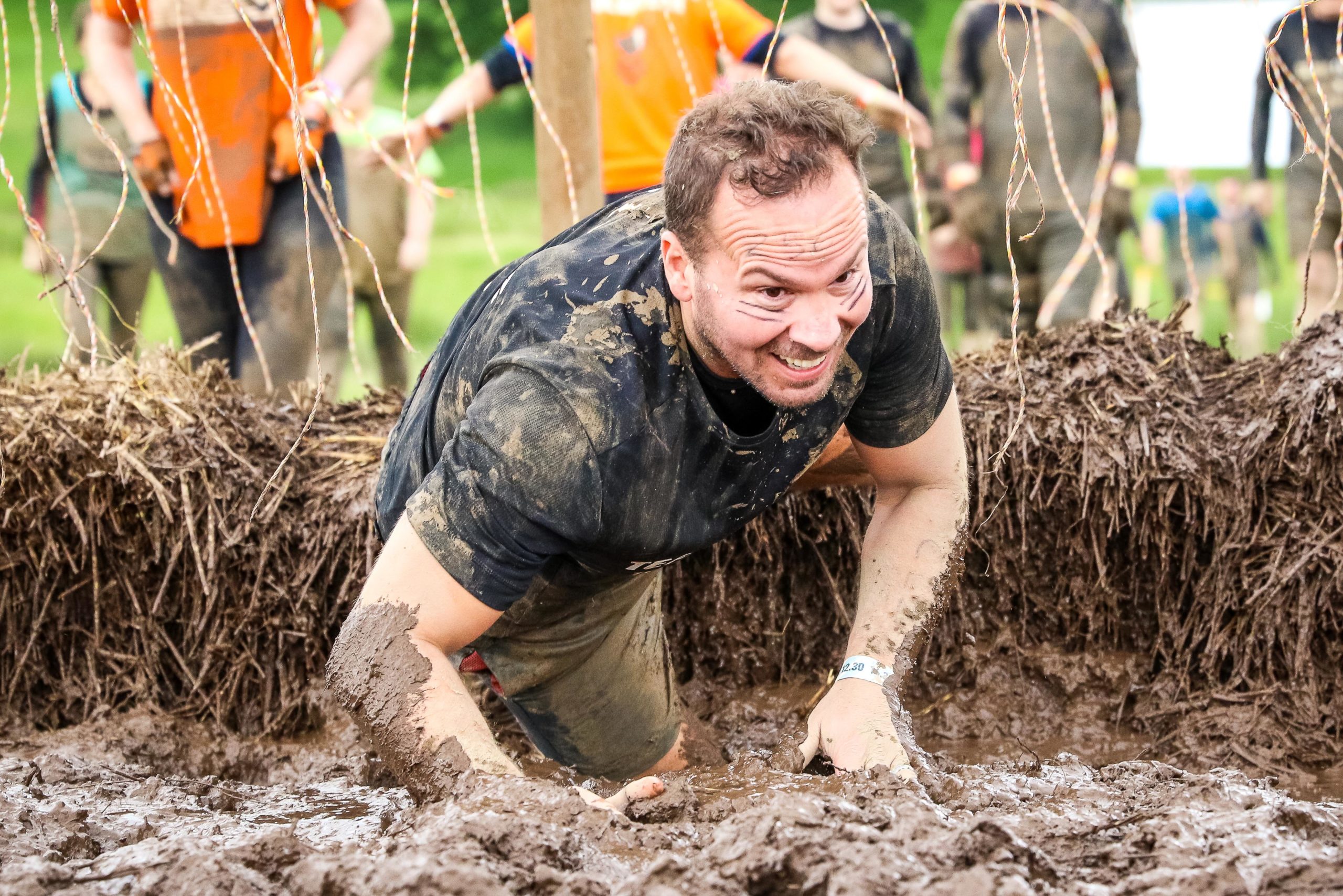 Participant crawling in the mud