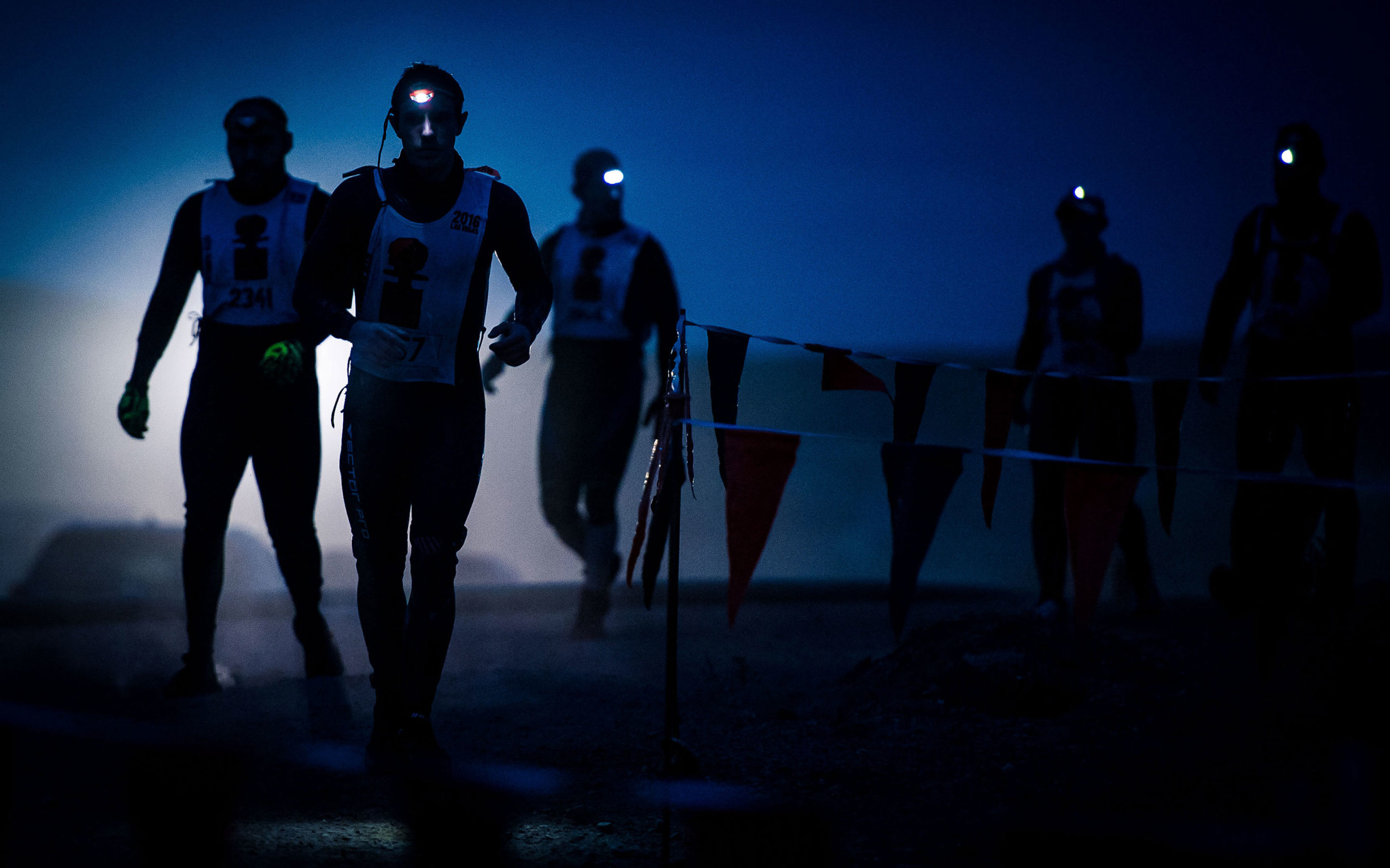 Participants running at night with flashlights on