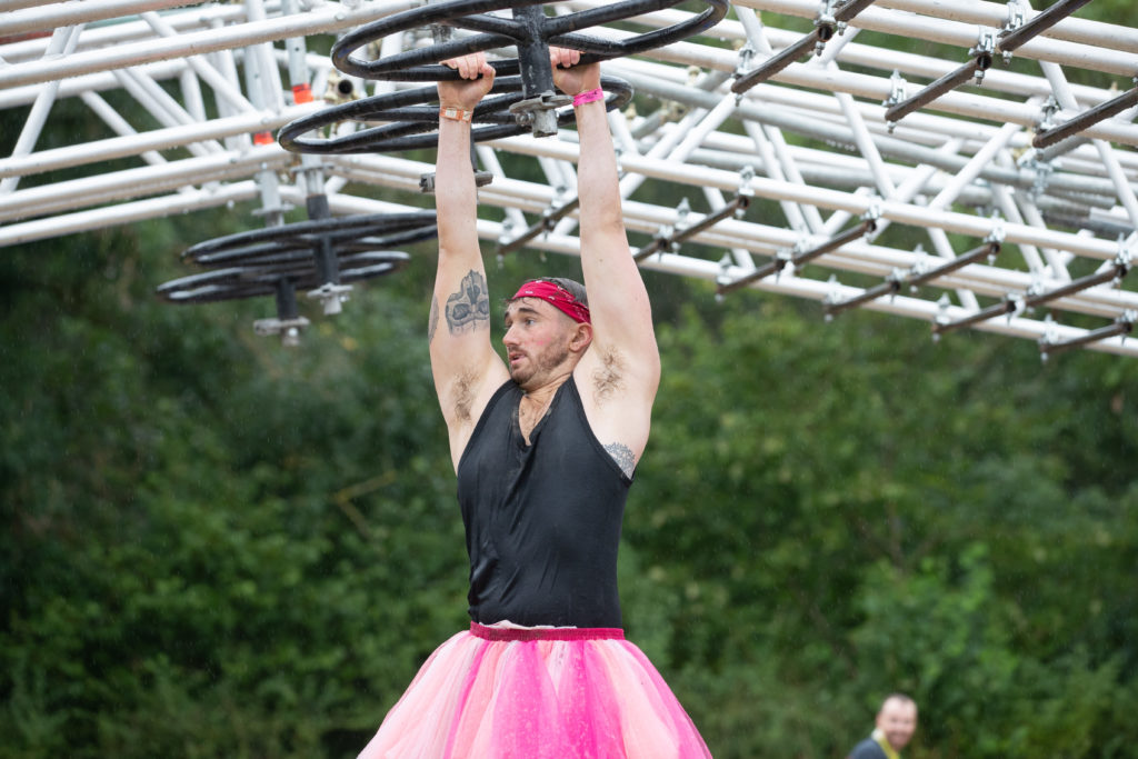 man in tutu on monkey bars