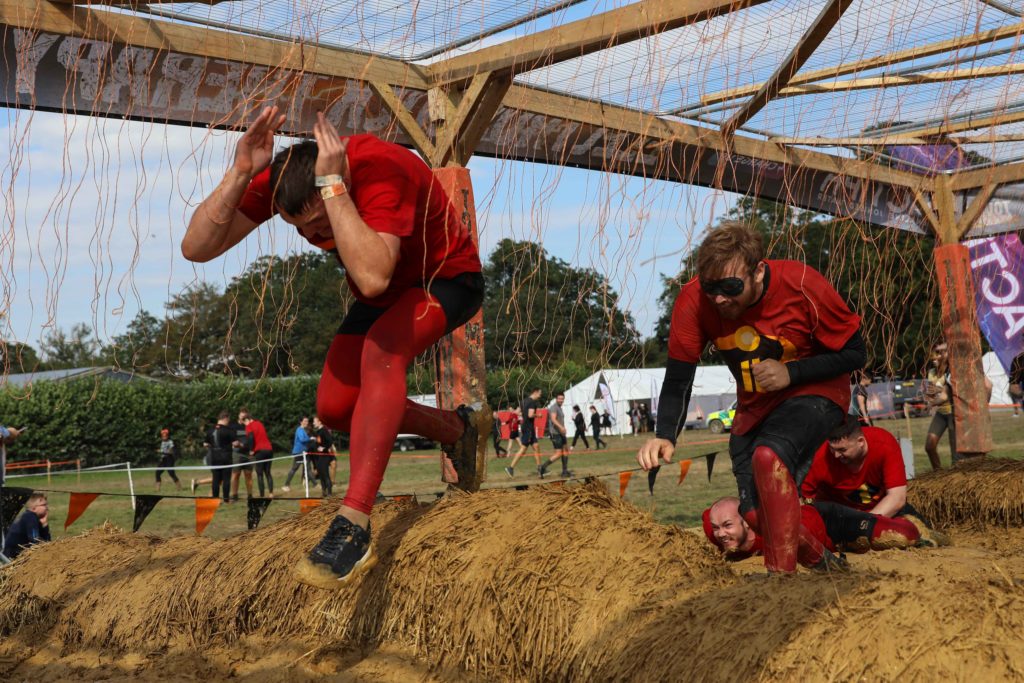 team running mud obstacle