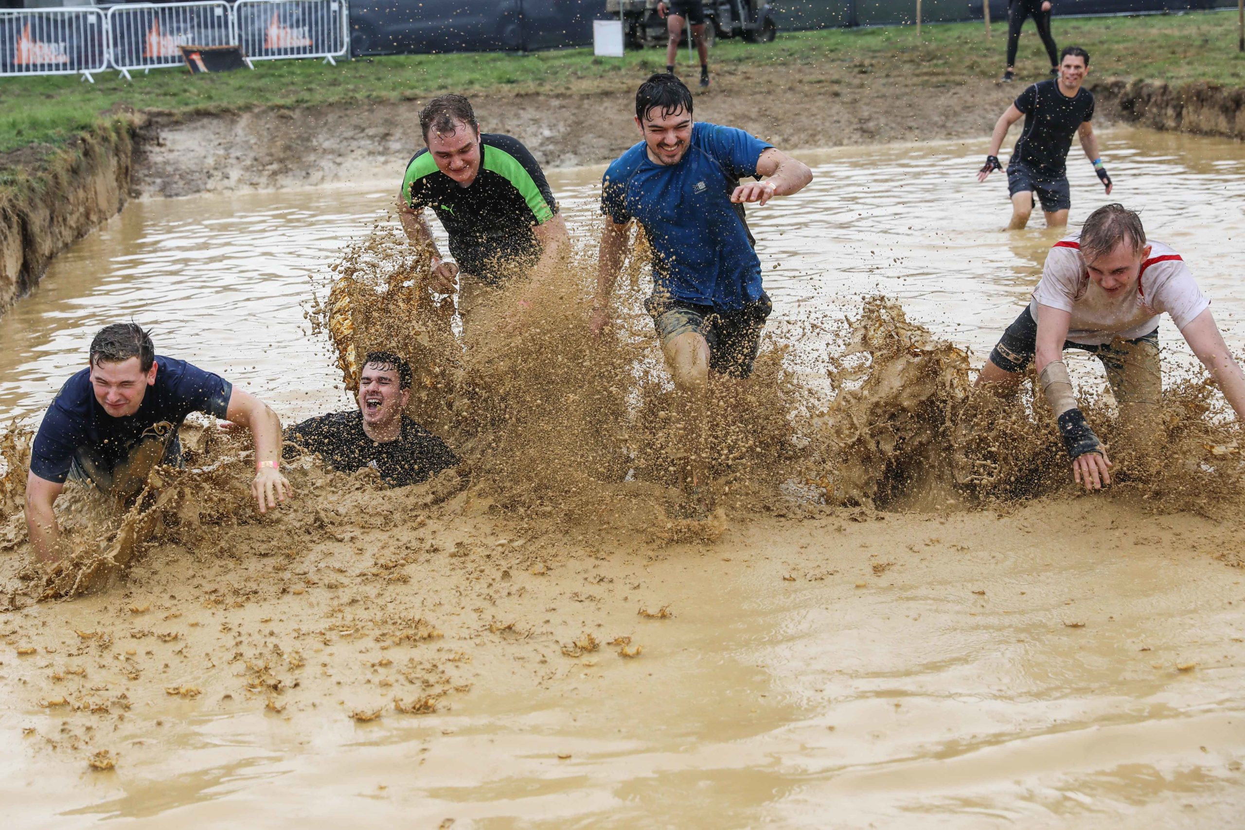 team boys running muddy water