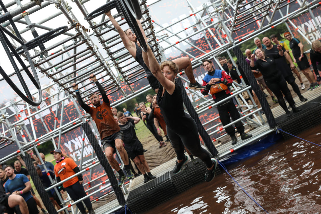 girl on monkey bars over water