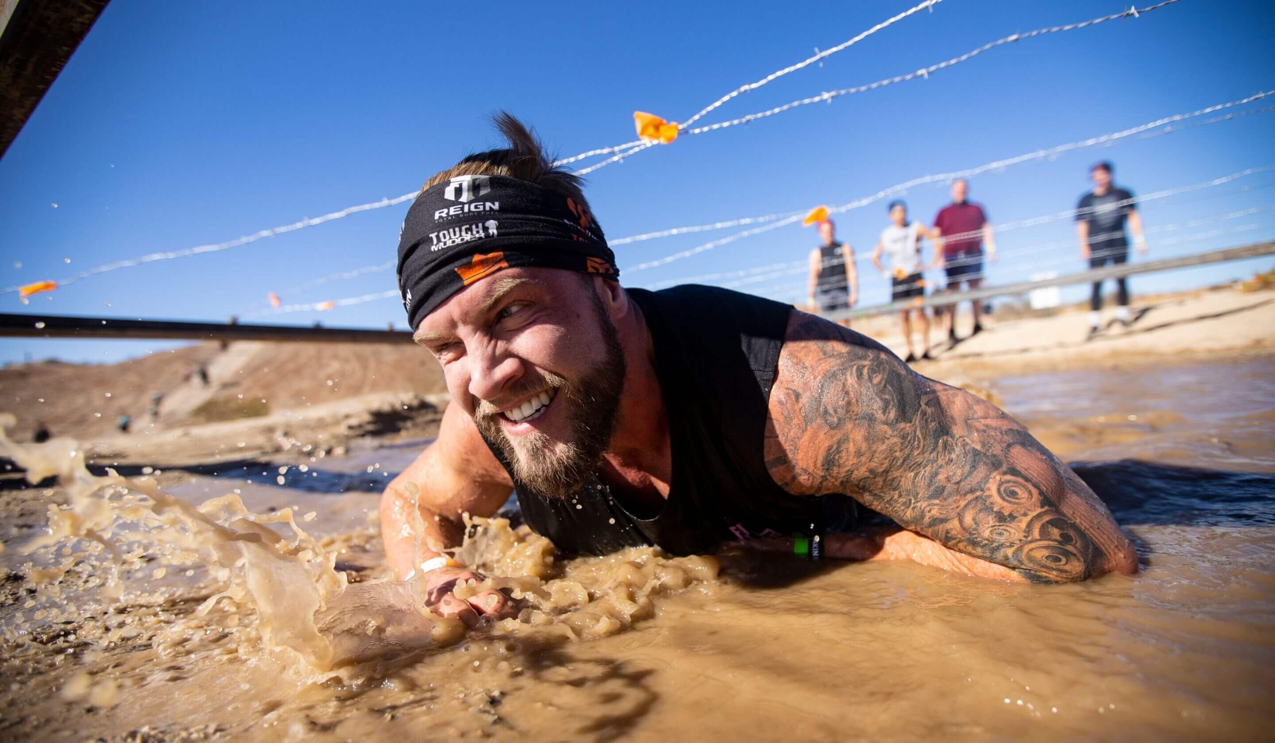 Participant crawling lowly to avoid barbed wires