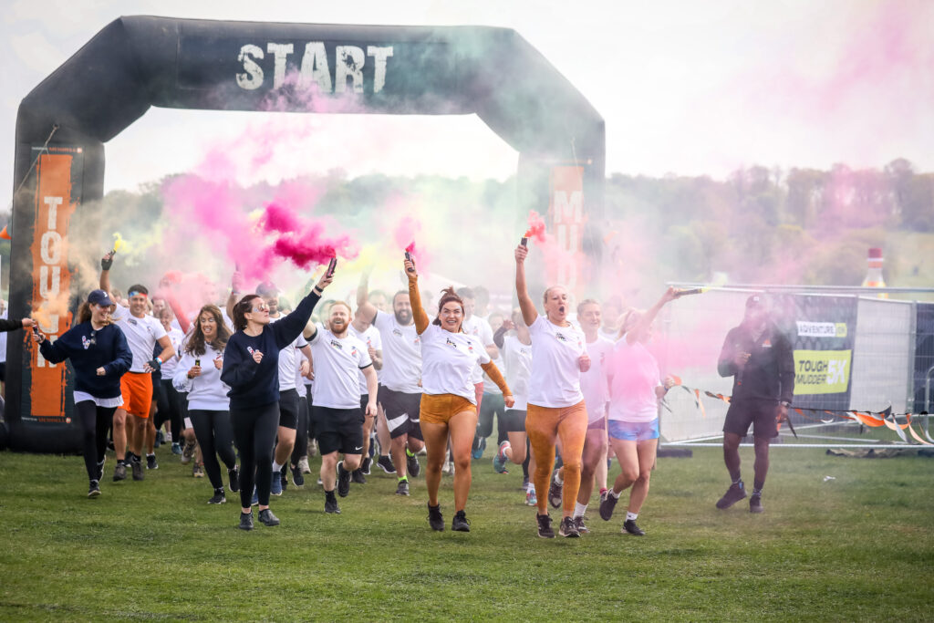 runners with flares three fold takes on Tough Mudder