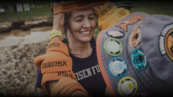 Tough Mudder Volunteer placing a headband on a participant.